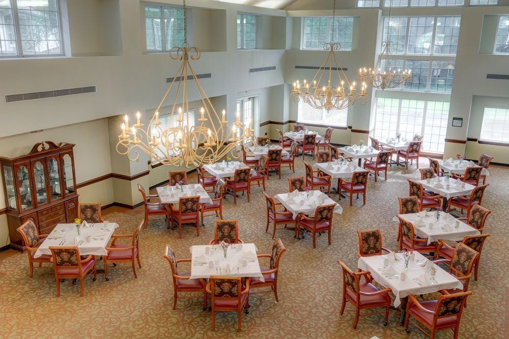 Chandelier-lit dining room with elegant furniture inside Ridgeland Place, a senior living community.