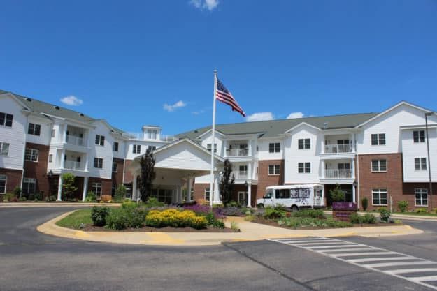 Flag waving at Silver Maples senior living community in Chelsea, showcasing suburb architecture.