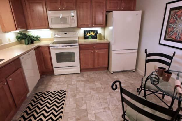 Interior view of a Silver Maples of Chelsea senior living unit featuring kitchen appliances, home decor and plants.
