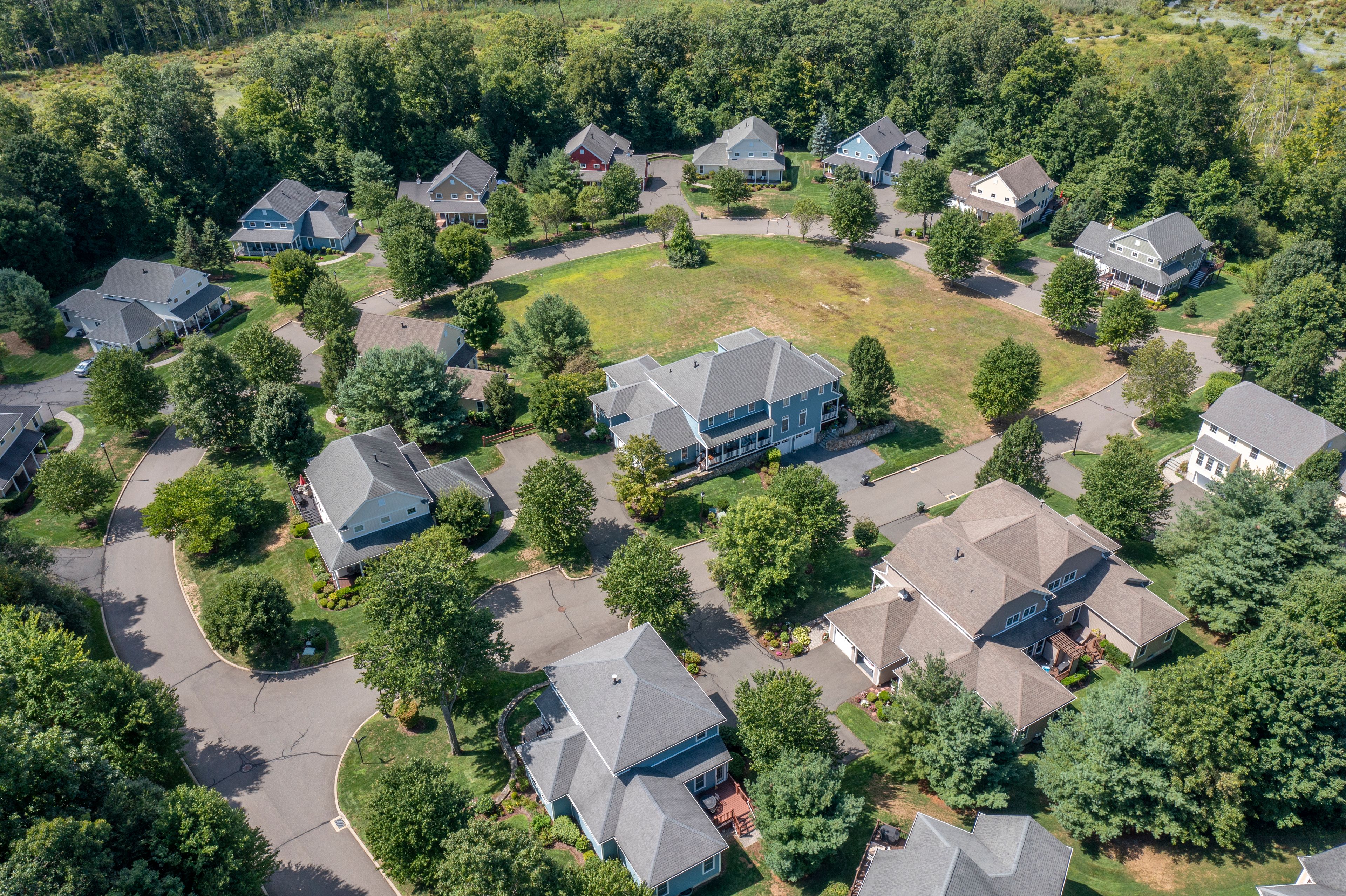 A drone view of Benson Woods: single family and duplex homes designed for active adult living. Each home features a main floor primary bedroom with en suite bath. Fully appointed kitchens, spacious living areas, and an attatched 2-car garage complete the homes.