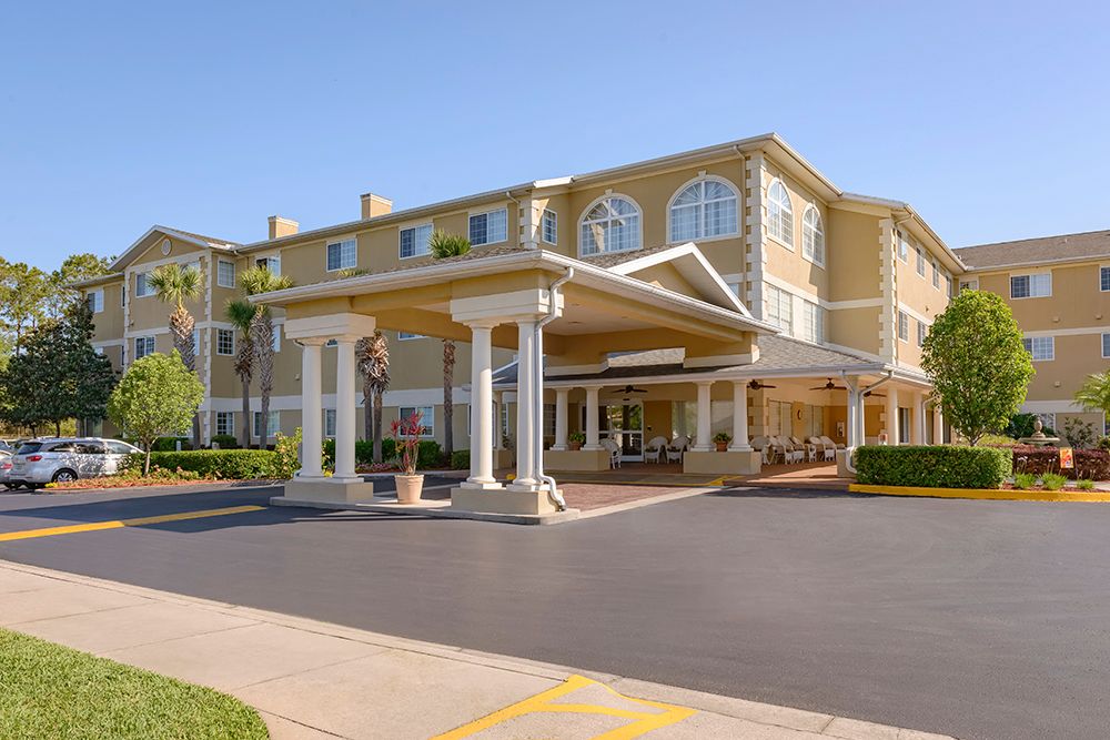 Architecture of The Bridge At Ocala senior living community with housing, car and urban scenery.